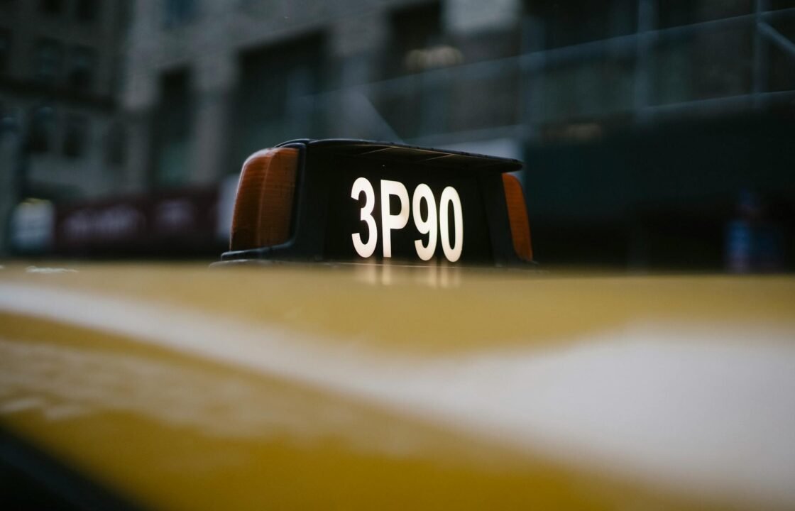 Close-up of a yellow taxi roof sign with 3P90 code in urban setting.