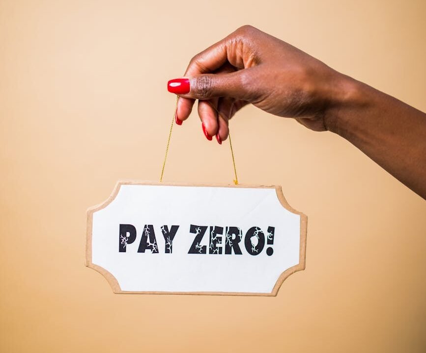 A hand holds a 'Pay Zero' sign, symbolizing cost savings or free content.